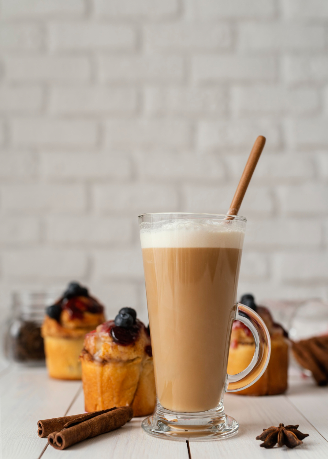 A chai latte with foam and cinnamon in a glass
