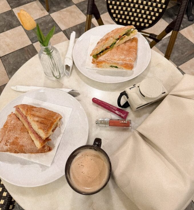 Fresh sandwiches and coffee on a marble table over the checkered café floor