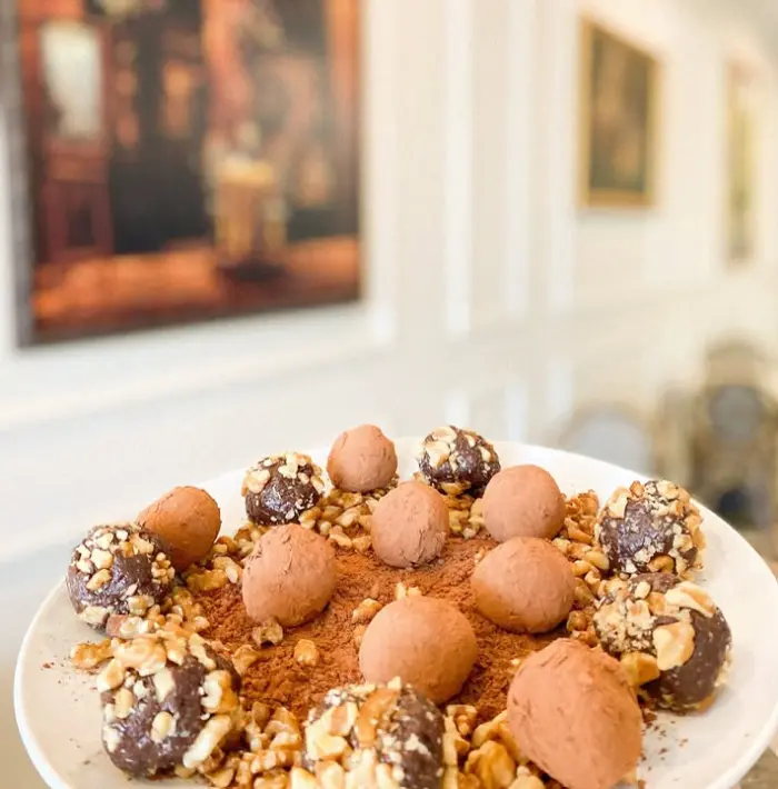 Chocolate truffles and nut covered sweets arranged on a plate